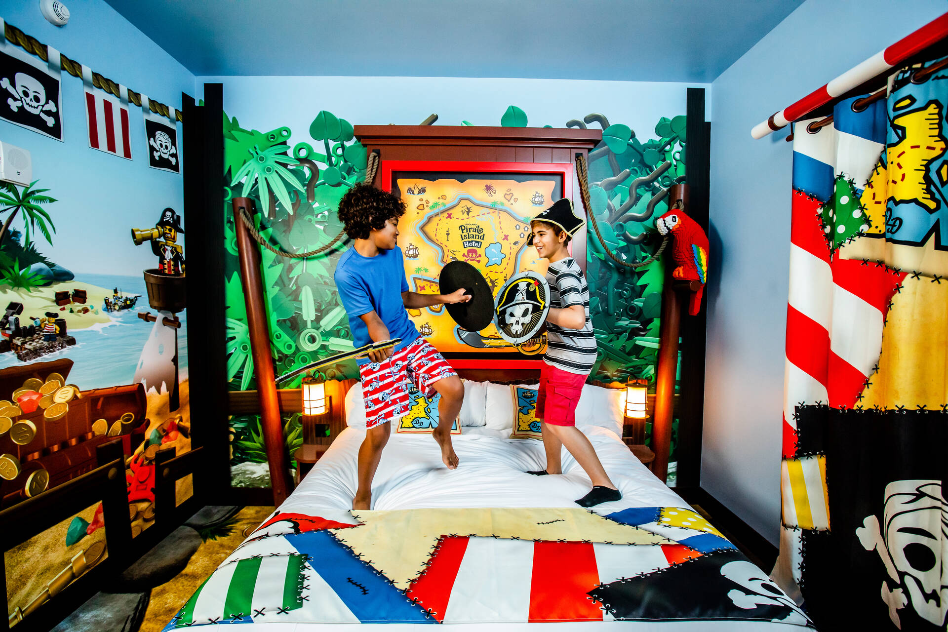 Two boys battle like pirates in a Pirate Island Hotel themed room.