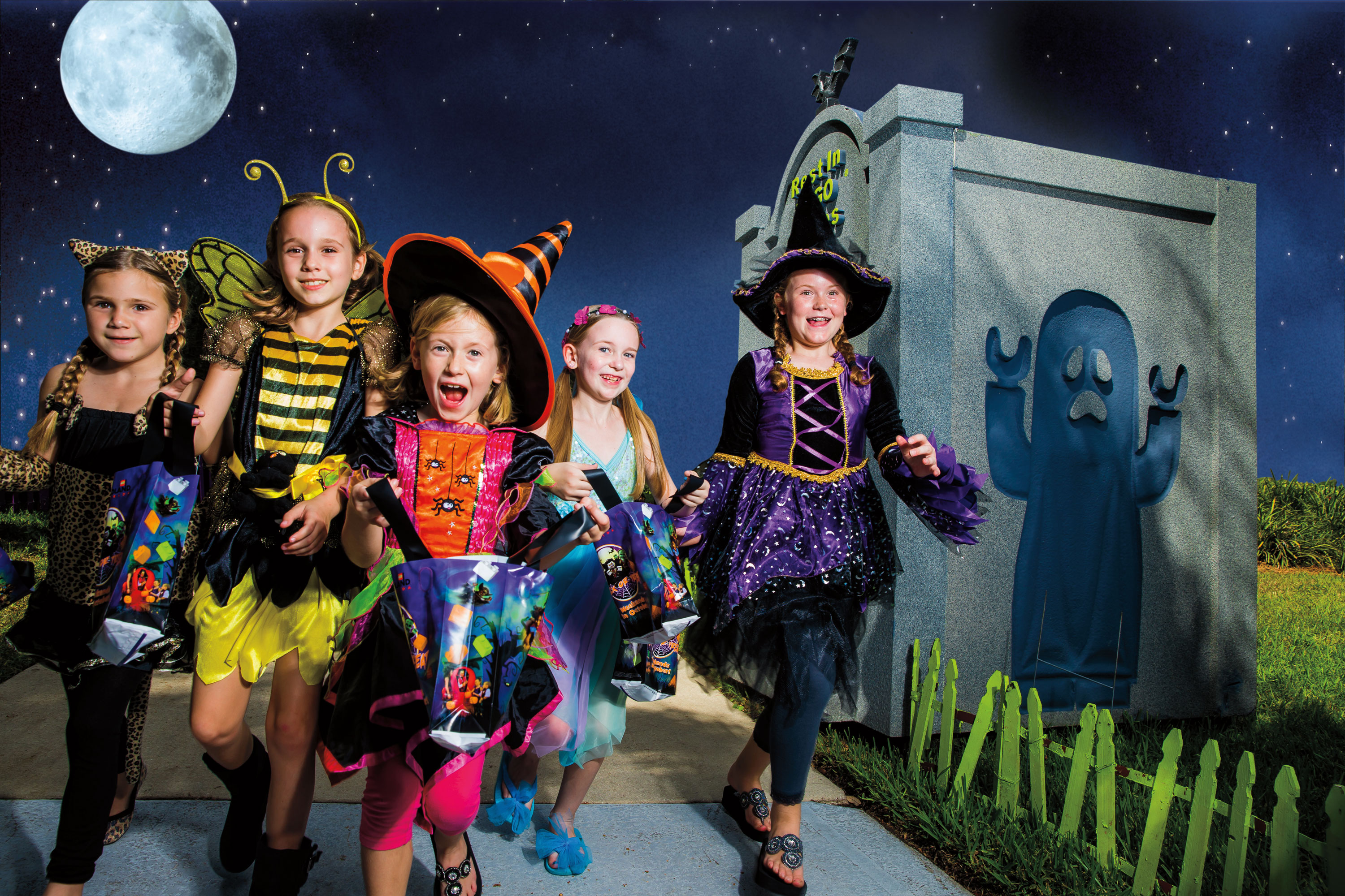 A group of girls dressed up in Halloween costumes go brick-or-treating