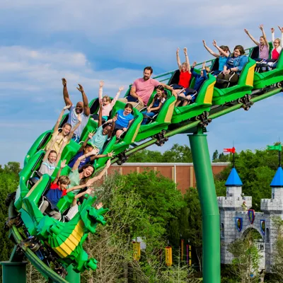 People riding with their hands up The Dragon at LEGOLAND California