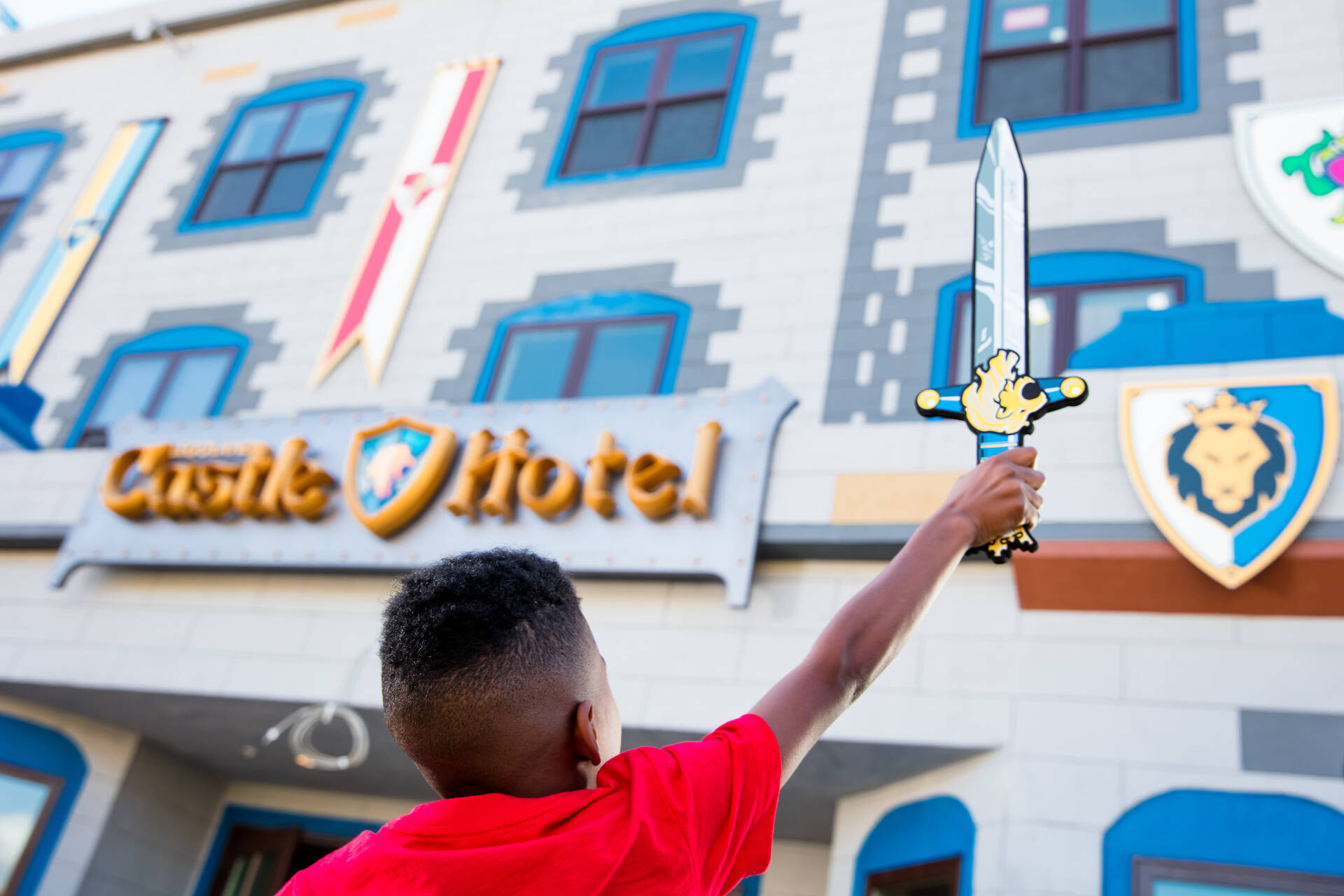 Kid strikes a heroic pose in front of the LEGOLAND Castle Hotel