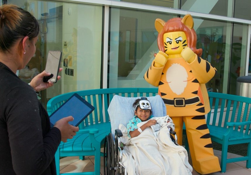 Tiger Lady posing with child from Rady Children's