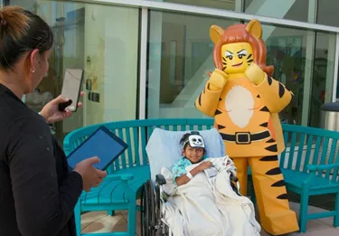 Tiger Lady posing with child from Rady Children's