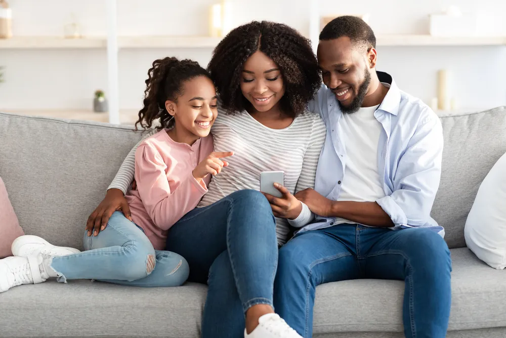 Family sits on couch and views their LEGOLAND Hotel booking confirmation