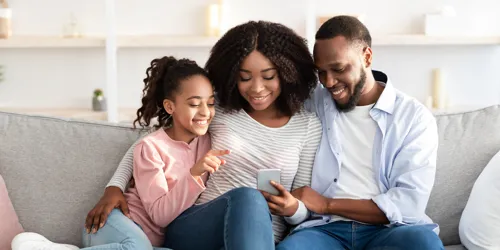 Family sits on couch and views their LEGOLAND Hotel booking confirmation