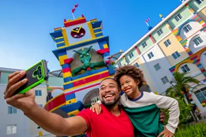 Father and son taking a selfie in front of the Legoland Hotel