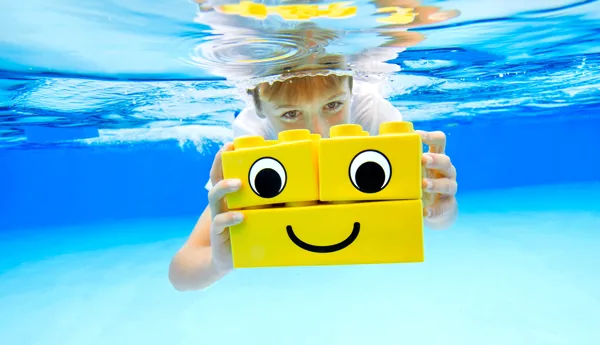 Kind in the pool with LEGO blockS