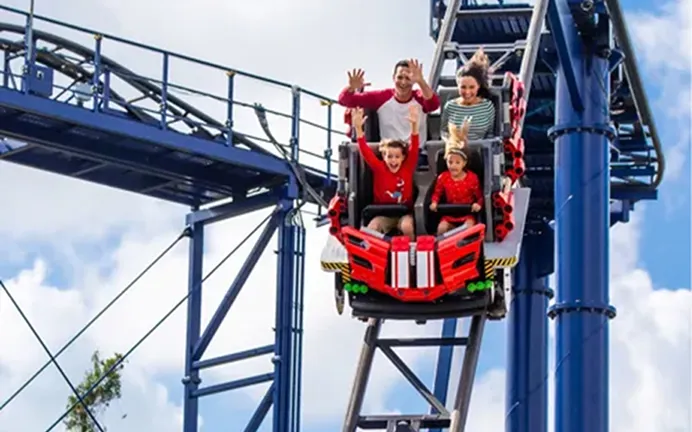 Guests riding a roller coaster with arms raised