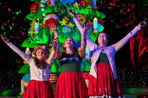3 Girls in Christmas attire in front of LEGO Christmas Tree