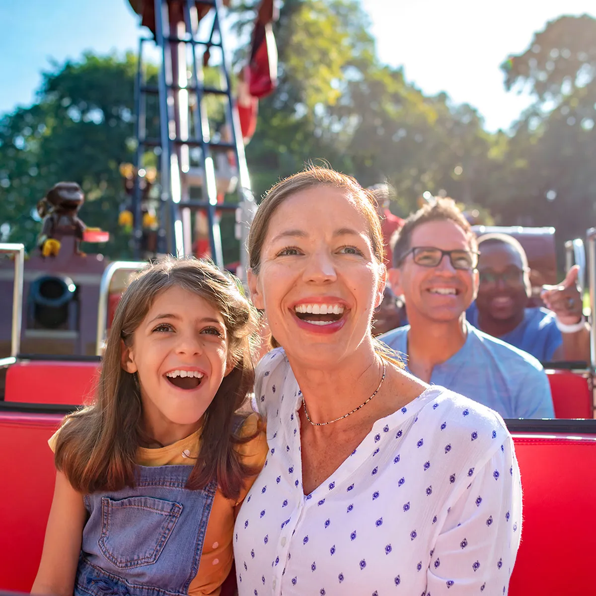 A family laughing together while riding a themed attraction