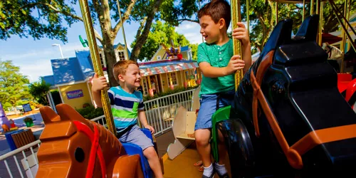 two children riding LEGO horses on the carousel