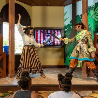 Two pirates show off their swordsmanship skills during a nightly performance.