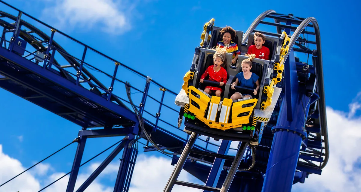 Guests riding a roller coaster with arms raised