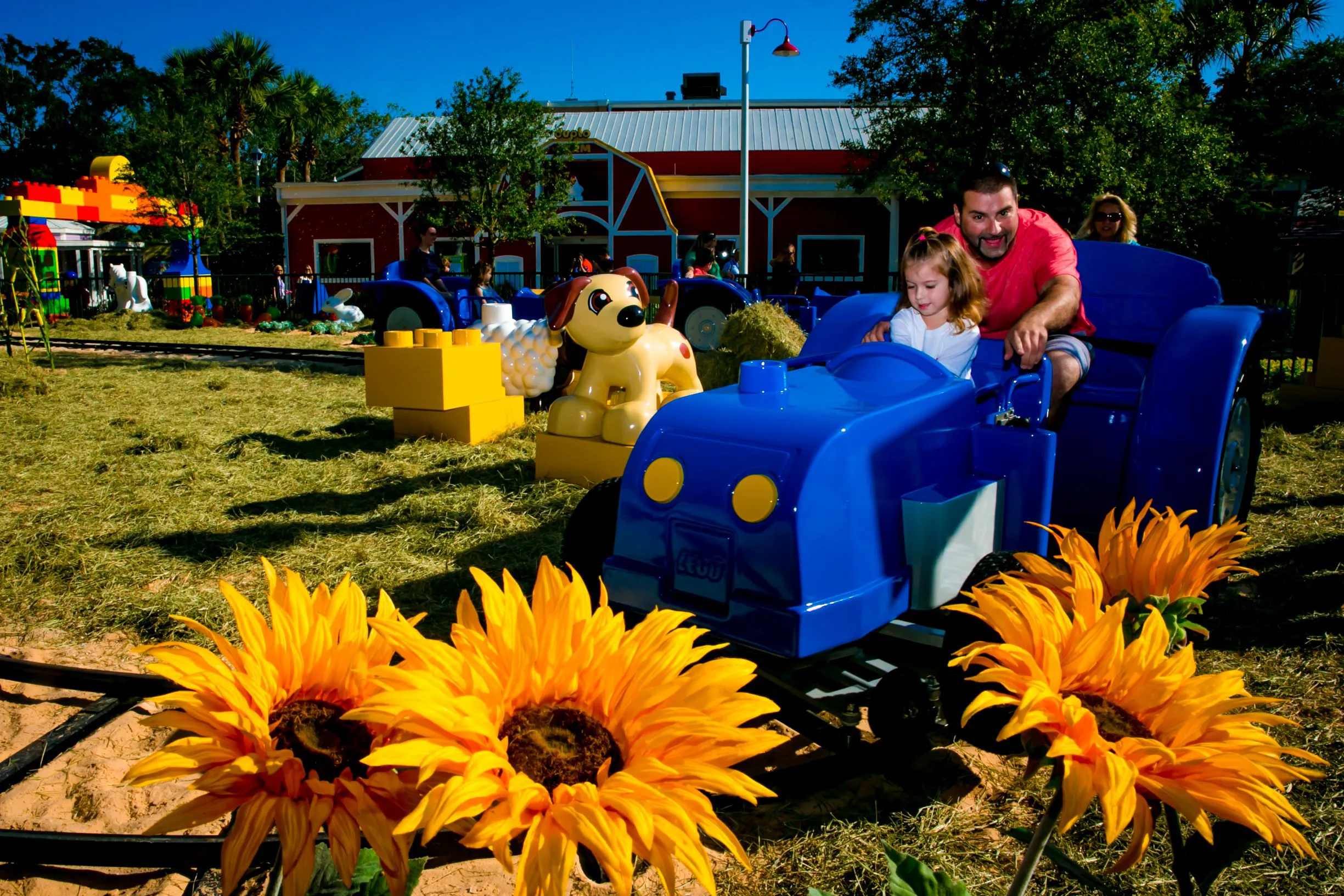 Girl and dad riding DUPLO Tractor