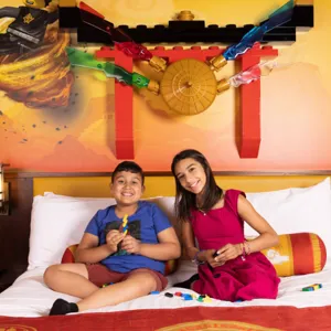 Kids Building LEGO on Hotel Bed