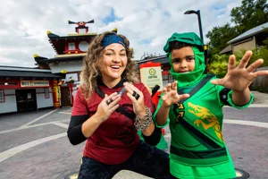 Kid with Ninja in front of LEGO NINJAGO Ride