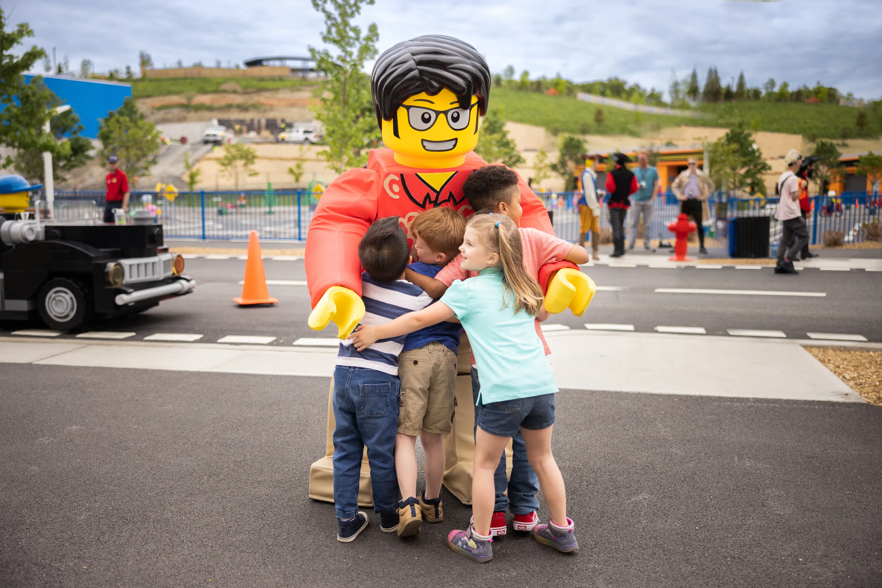 Tourist Tom welcomes a group of kids to LEGO CITY with a big hug