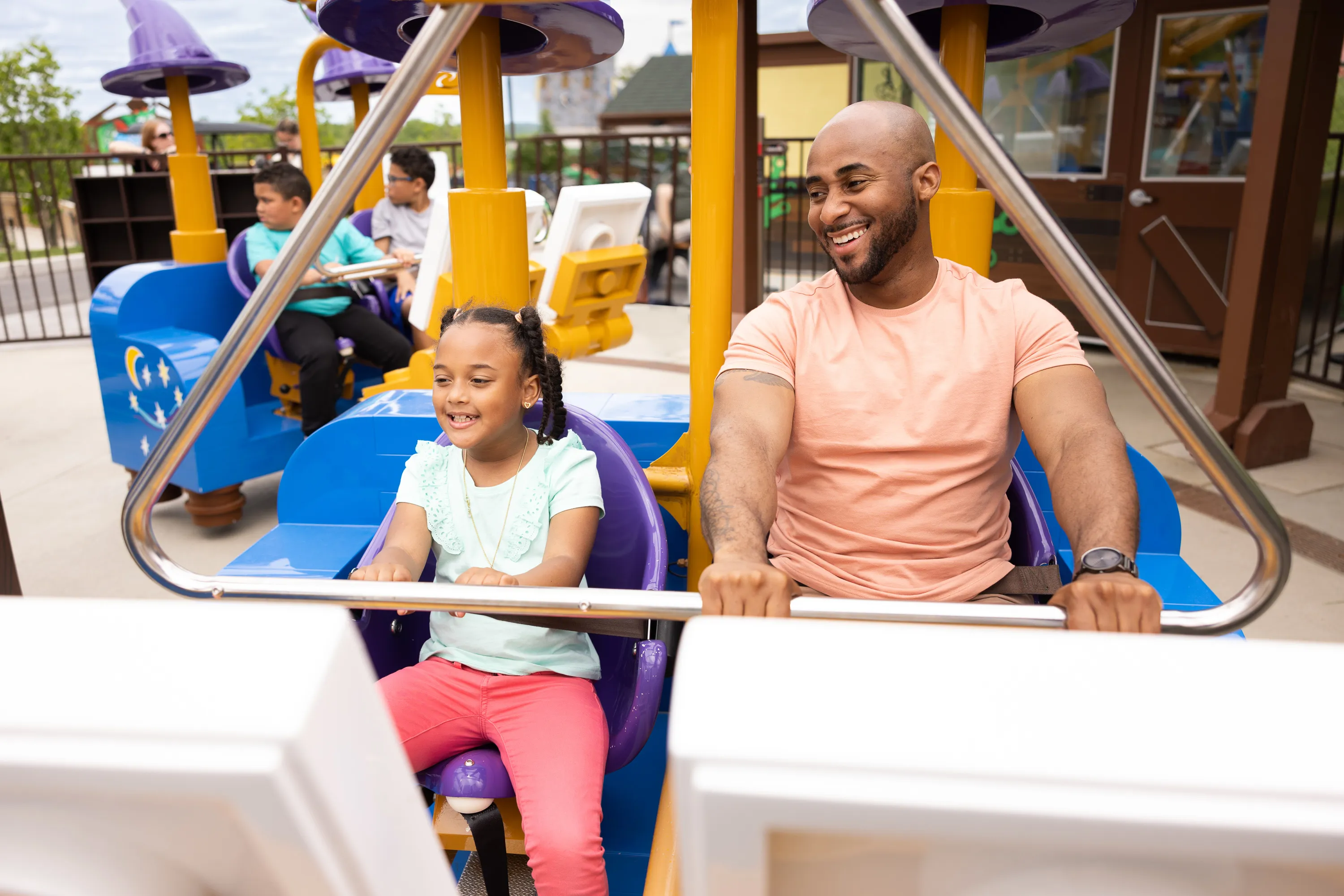 A father and daughter ready to ride Merlin's Flying Machines