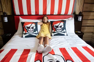 Girl Relaxes in a Pirate Room King Size Bed