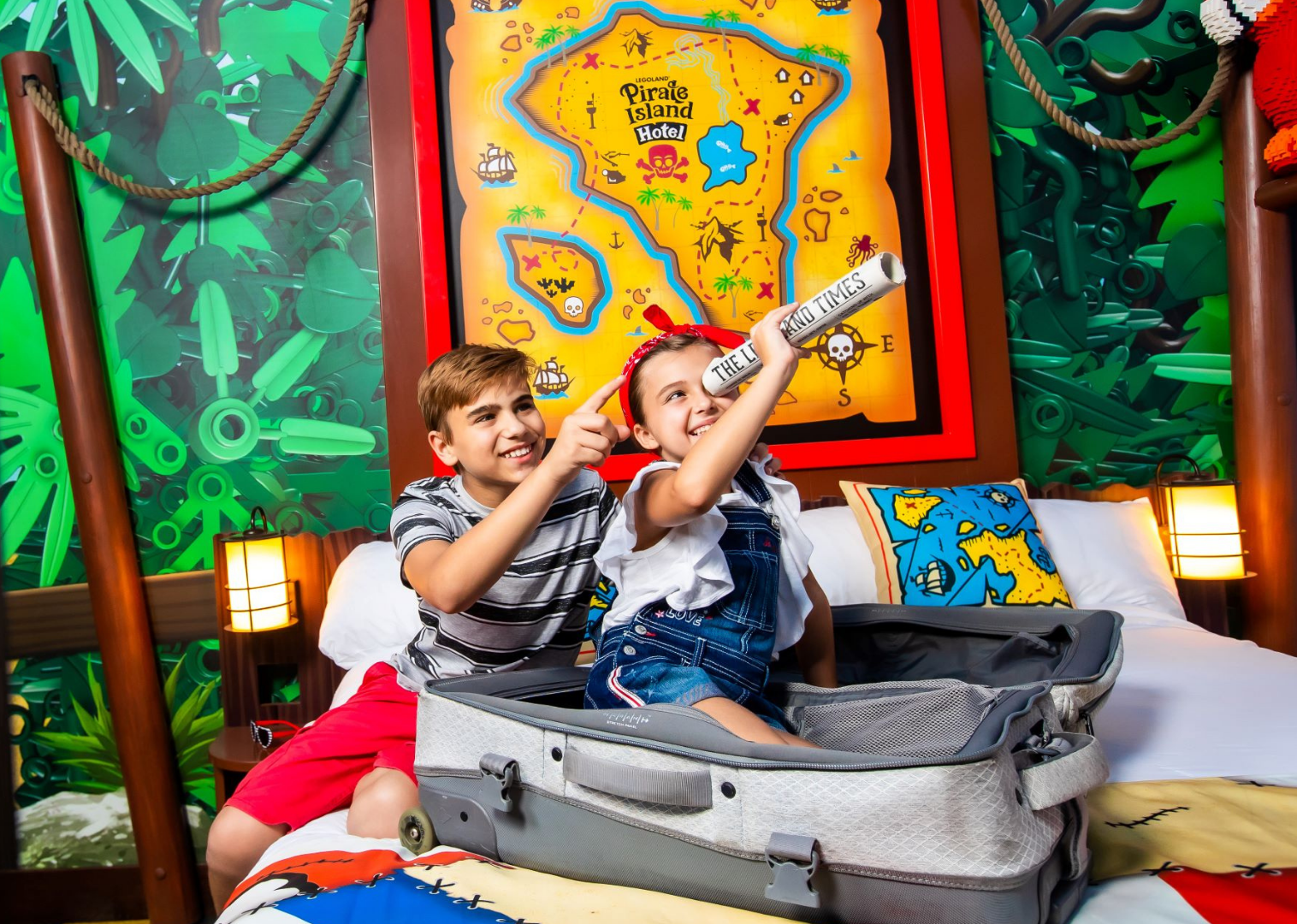Two kids look through a monocular in a pirate-themed hotel room